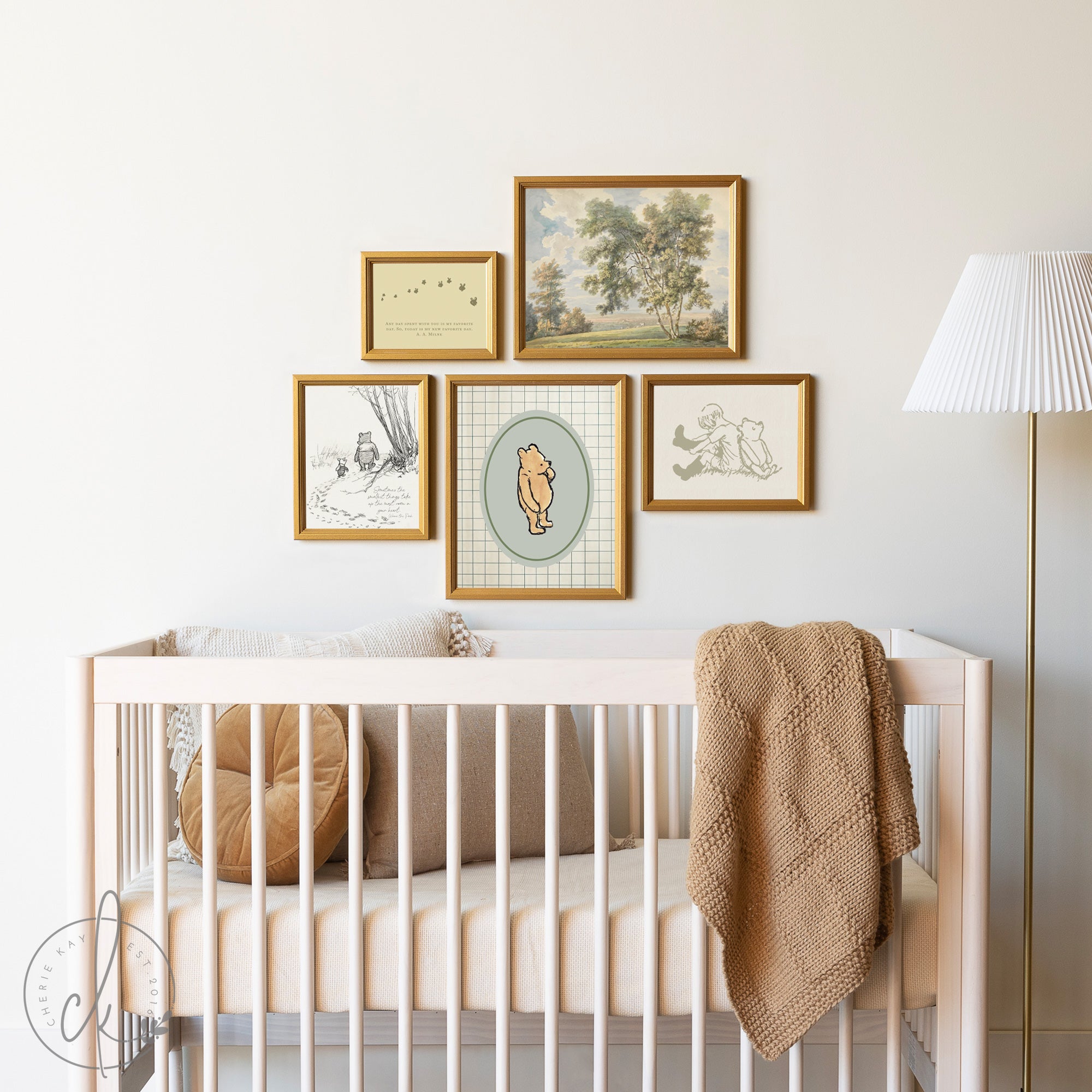 This vintage Winnie the Pooh gallery wall art set is displayed above a crib. It features framed illustrations of Pooh Bear, Piglet, and Christopher Robin, and a serene landscape. This is the perfect nursery decor for a timeless kids room.