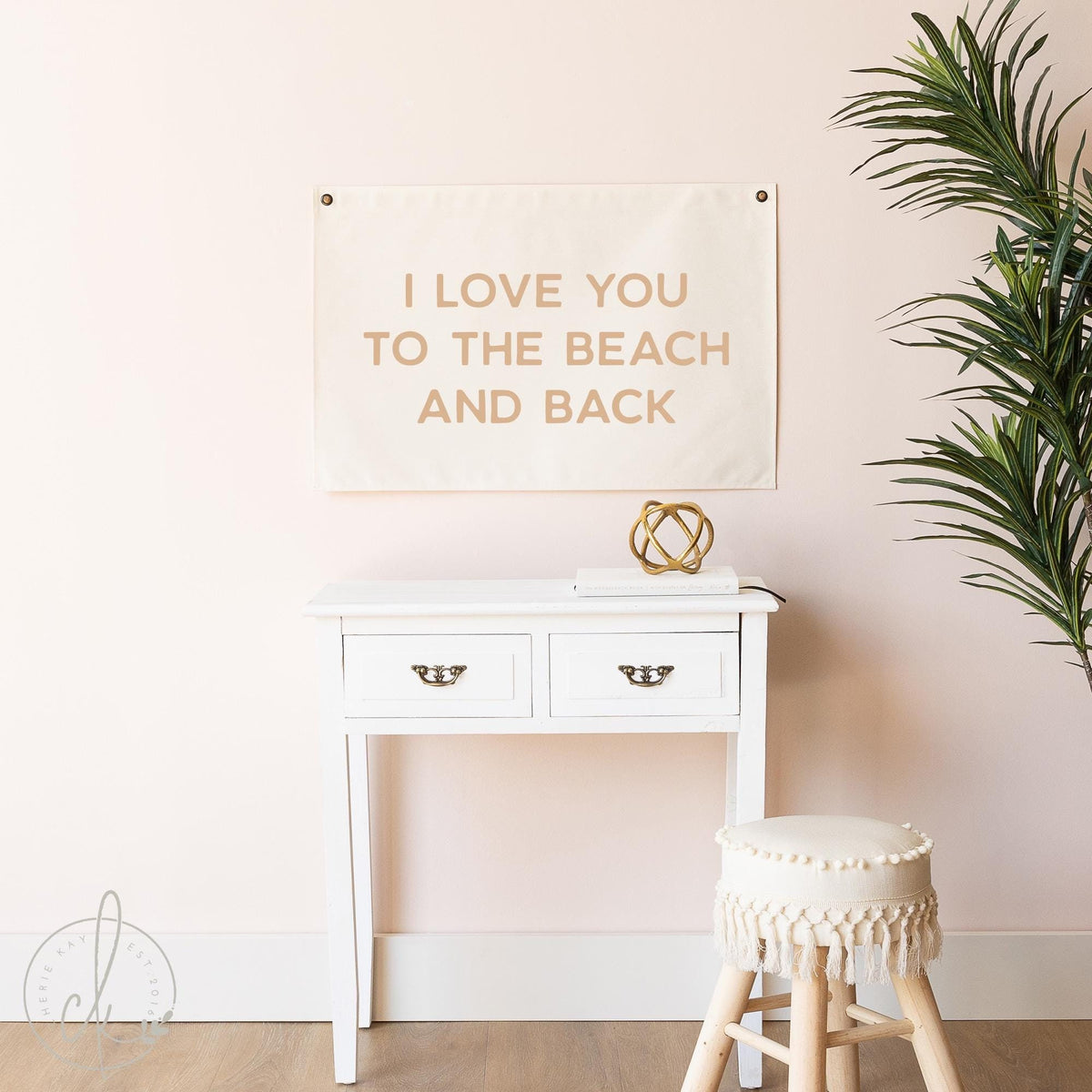 Coastal canvas wall sign with the phrase I Love You to the Beach and Back displayed above a white console table in a beach-themed room. Perfect for beach house decor, nursery, or kids&amp;#39; room, featuring neutral tones and a minimalist design.