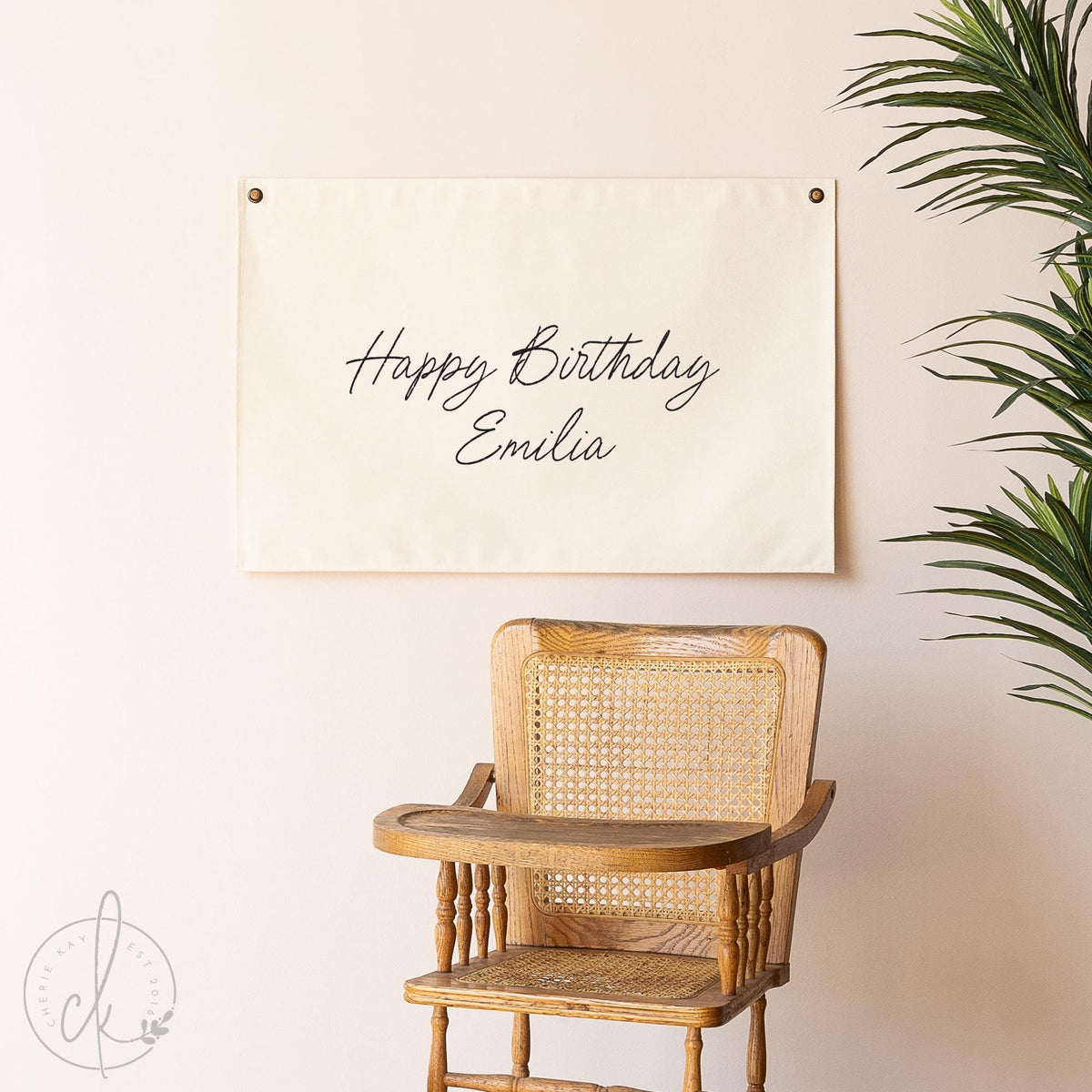 A personalized Happy Birthday canvas sign with a custom name is displayed on a wall above a wooden chair, perfect for birthday decor, teen room decoration, or as a unique birthday gift for boys and girls.