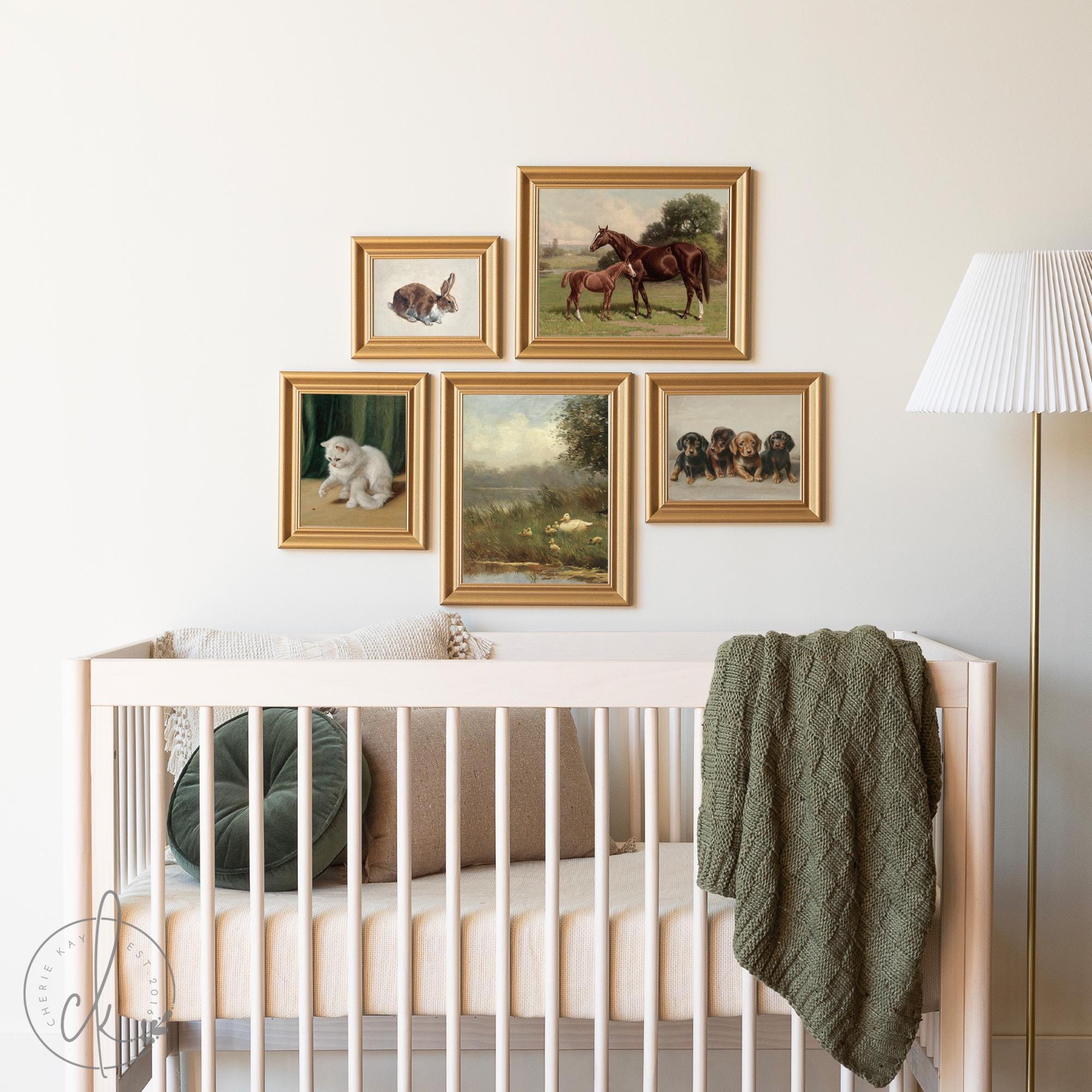 A cozy nursery with a wooden crib and a gallery wall of five gold-framed animal prints, including a horse, rabbit, kitten, puppies, and a countryside scene, creating a warm, inviting atmosphere.