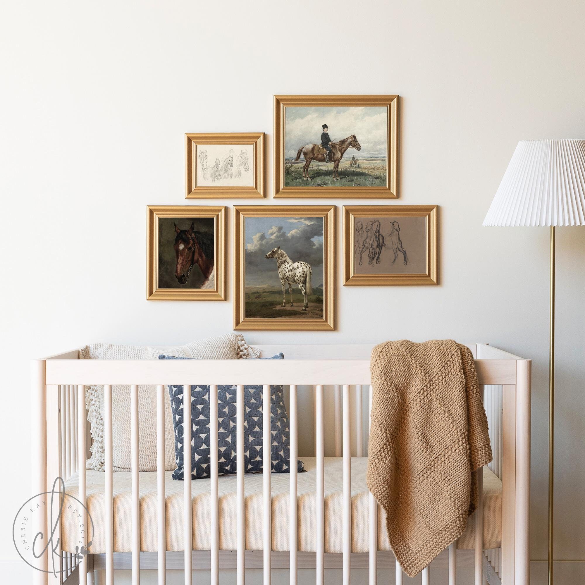 Elegant nursery featuring a horse-themed gallery wall with vintage-inspired equestrian artwork in gold frames, above a white crib with neutral bedding and a cozy knit blanket.