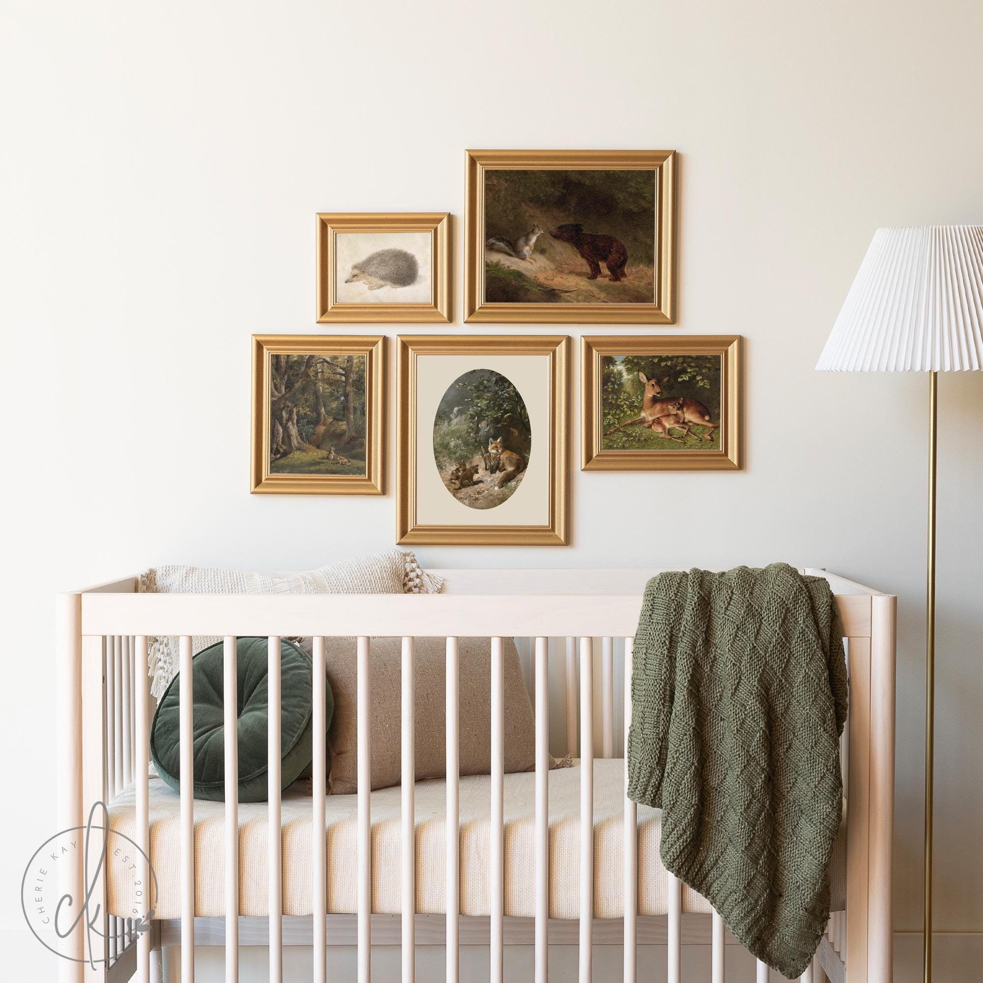 Nursery with a wooden crib and a gold-framed gallery wall featuring vintage-style woodland animal prints